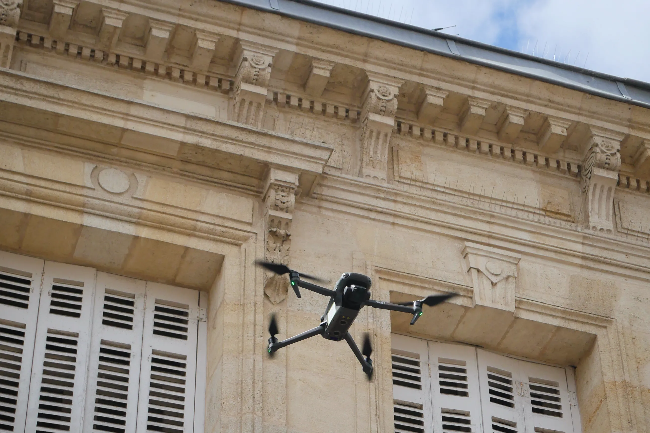 Drone DJI Mavic 3 Enterprise volant au plus près d’une façade haussmannienne en pierre à Bordeaux centre