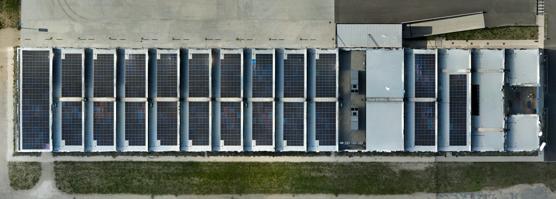 Orthophoto par drone de la toiture industrielle en sheds couverte de panneaux photovoltaïques en Gironde